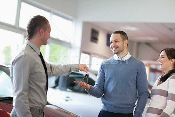 [[stock_photo]]: Vendeur · clés · de · voiture · souriant · couple · voiture · costume