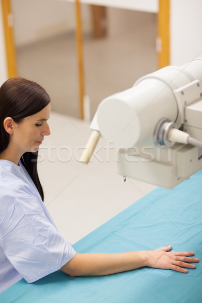 Woman positioning her arm on a medical table in a radiography Stock photo © wavebreak_media