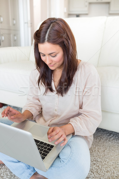 Mujer mirando portátil mujer sonriente sonriendo casa Foto stock © wavebreak_media