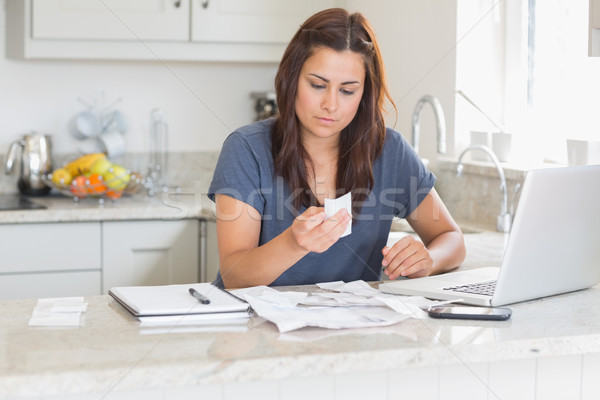 Brunette looking over bills in kitchen Stock photo © wavebreak_media