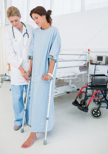 Doctor helping patient in crutches at hospital Stock photo © wavebreak_media