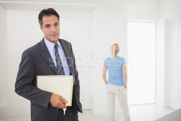 Well dressed real estate agent with blurred woman in background Stock photo © wavebreak_media