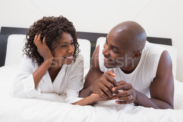 Happy couple lying on bed together Stock photo © wavebreak_media