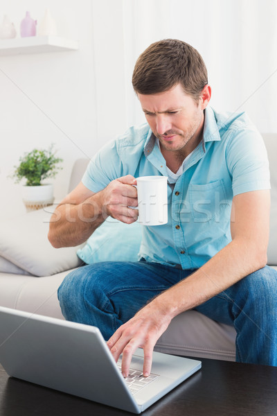 Foto stock: Concentrarse · hombre · usando · la · computadora · portátil · casa · sesión · sofá