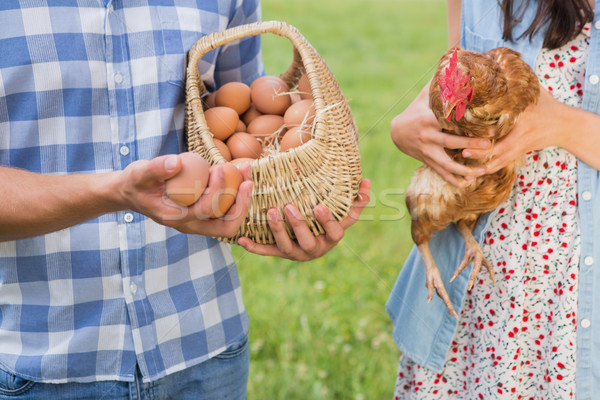 Happy farmers holding chicken and eggs Stock photo © wavebreak_media
