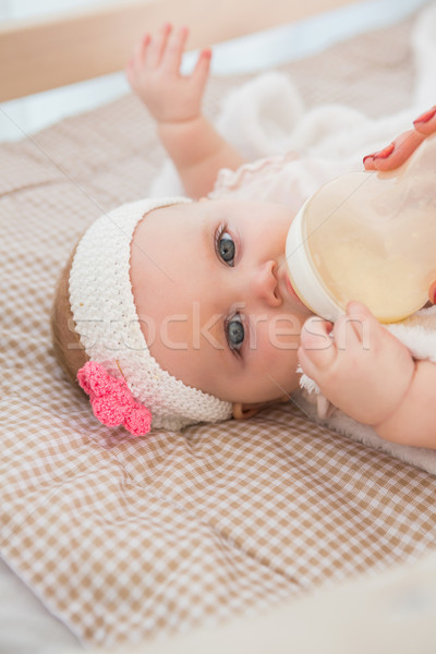 Happy cute baby girl drinking her baby bottle  Stock photo © wavebreak_media