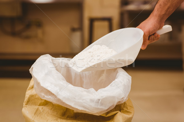 Stock photo: Baker scooping flour out of sack