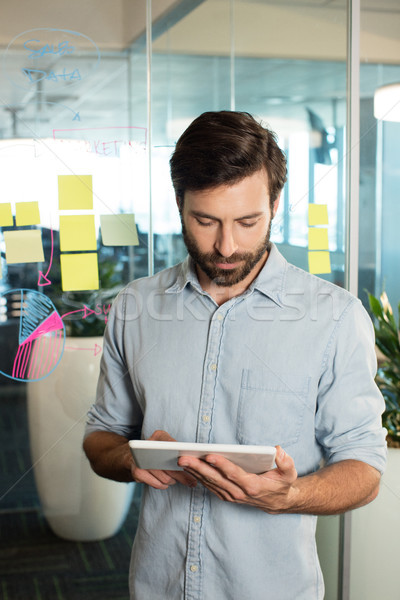 Businessman using digital tablet against strategy on glass Stock photo © wavebreak_media