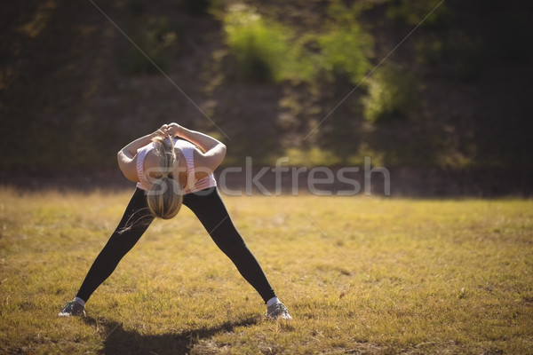 Woman performing stretching exercise during obstacle course Stock photo © wavebreak_media