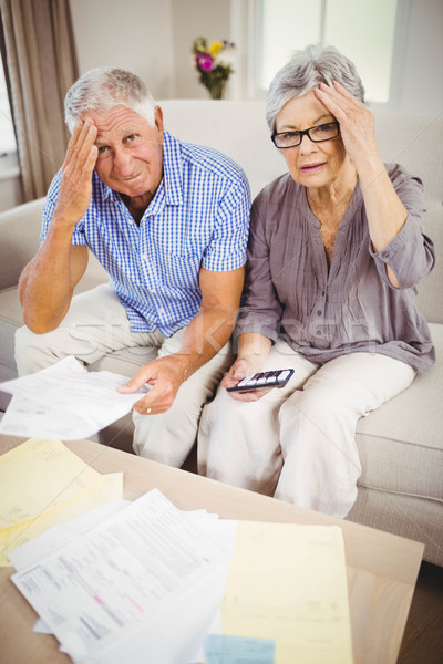 Stock photo: Senior couple with bills looking worried