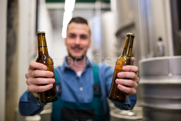 Stock photo: Brewer holding two beer bottle