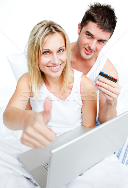 Couple in bed buying on-line with thumb up Stock photo © wavebreak_media