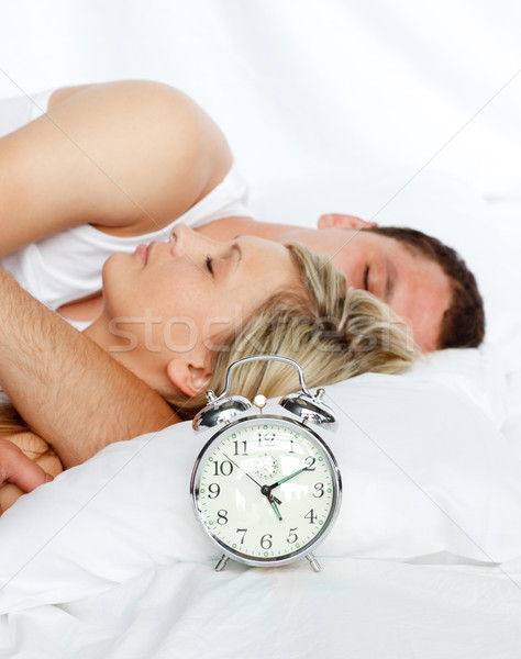 Stock photo: Couple in bed with focus in alarm clock
