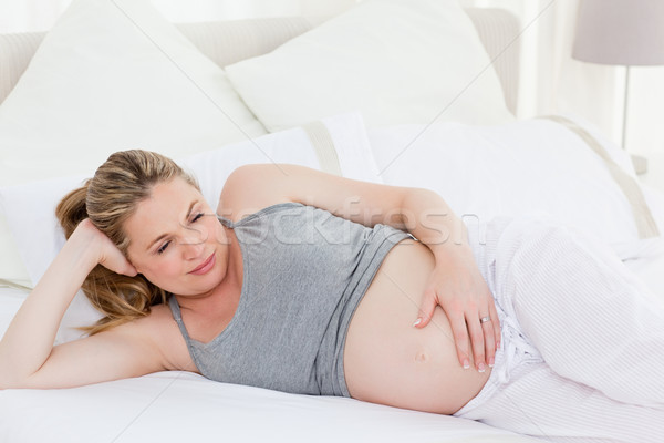 Beautiful woman with her hands on her belly at home Stock photo © wavebreak_media