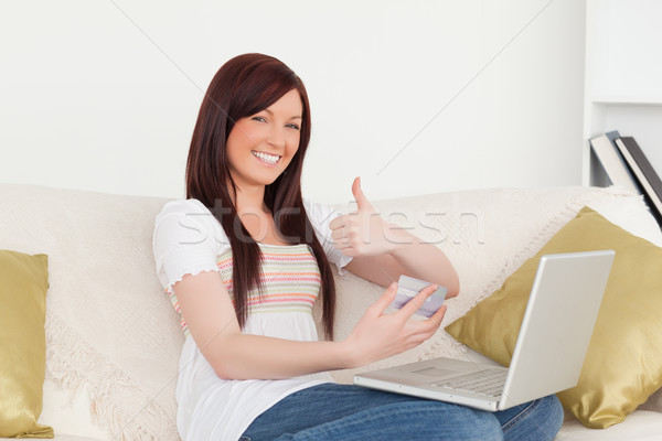 Vonzó nő ül kanapé gyártmány fizetés internet Stock fotó © wavebreak_media