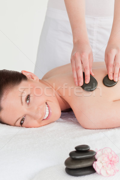 Smiling young redhead woman having a hot stone massage Stock photo © wavebreak_media