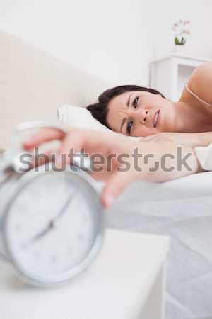 Portret femeie ceas desteptator dormitor mâini pat Imagine de stoc © wavebreak_media
