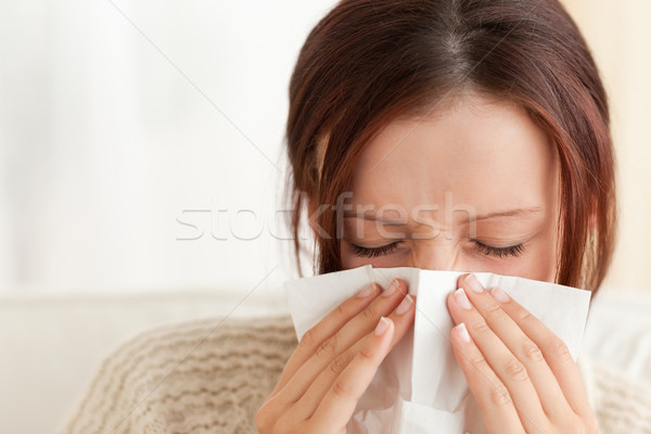 Woman blowing her nose in a living room Stock photo © wavebreak_media