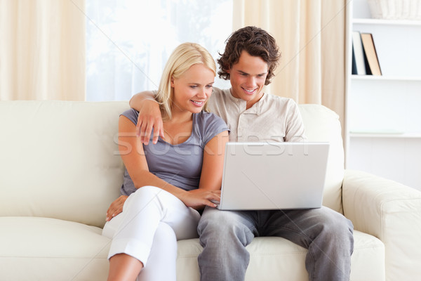 Friendly couple using a notebook in their living room Stock photo © wavebreak_media