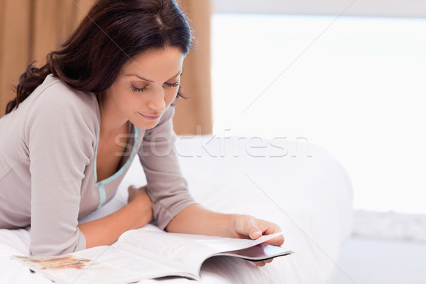 年輕女子 閱讀 雜誌 床 快樂 家 商業照片 © wavebreak_media