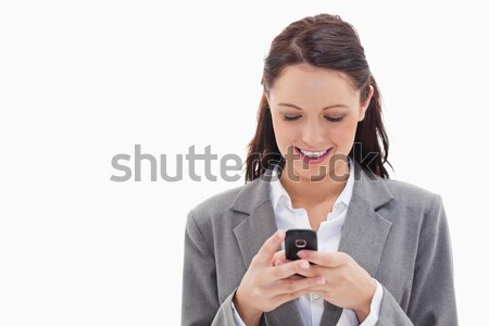Close-up of a businesswoman smiling and writing a text message against white background Stock photo © wavebreak_media
