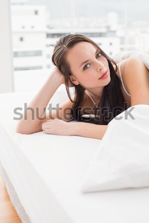A woman looking slightly to the side with her head resting on her hand, and her other hand on the be Stock photo © wavebreak_media