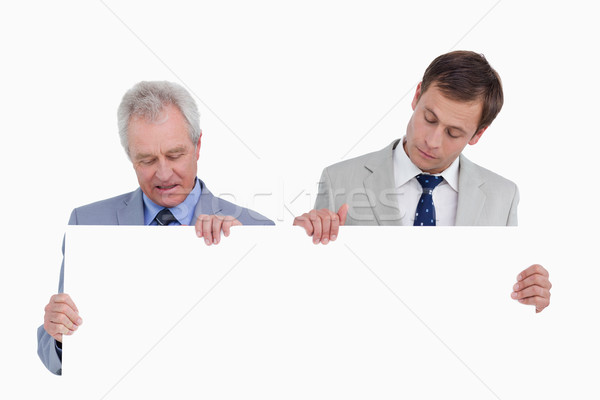 Tradesmen looking at blank sign in their hands against a white background Stock photo © wavebreak_media