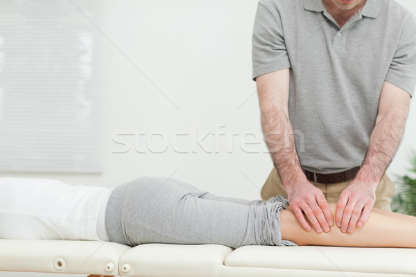 Woman lying while a man is massaging her calves in a room Stock photo © wavebreak_media