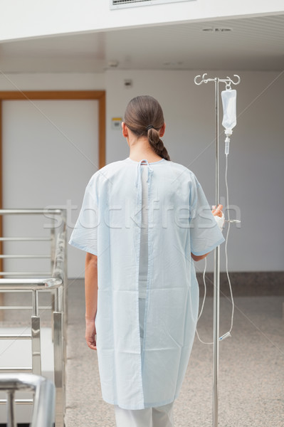 Rear view of a female patient holding a drip stand in hospital corridor Stock photo © wavebreak_media