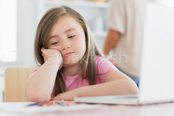 Little girl in kitchen with laptop paper and colouring pencils lookinf bored Stock photo © wavebreak_media