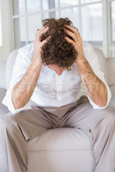 Stock photo: Well dressed man sitting with head in hands at home