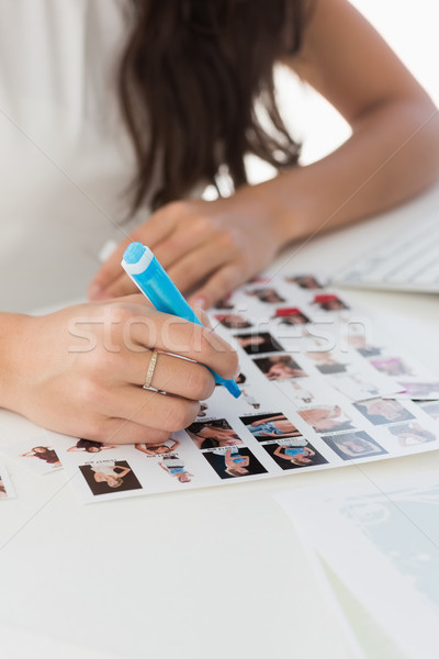 Editor working at desk marking a contact sheet Stock photo © wavebreak_media