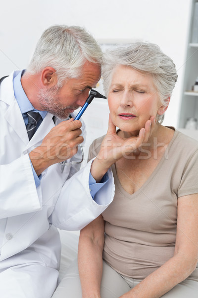 Male doctor examining senior patients ear Stock photo © wavebreak_media