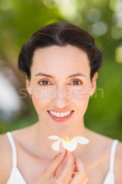 Happy brunette holding a white flower Stock photo © wavebreak_media