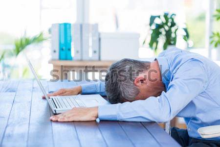 Businessman sleeping by computer at desk Stock photo © wavebreak_media