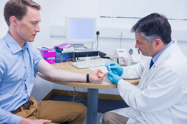 Stock photo: Doctor testing his patients blood