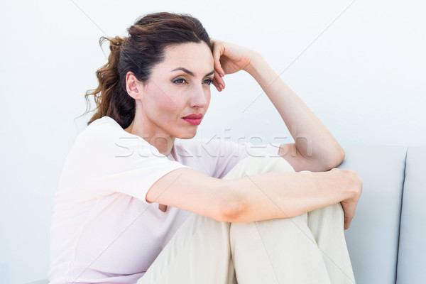 Sad brunette sitting on the couch Stock photo © wavebreak_media