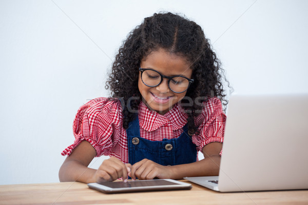 Smiling businesswoman using tablet while sitting at desk Stock photo © wavebreak_media