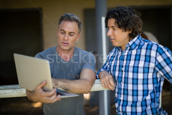 Due maschio amici utilizzando il computer portatile ranch computer Foto d'archivio © wavebreak_media