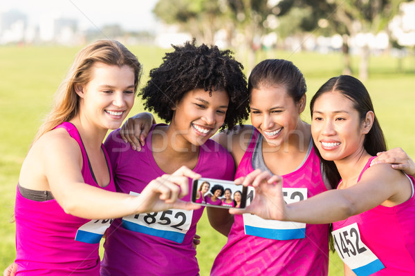 Runners supporting breast cancer marathon and taking selfies Stock photo © wavebreak_media
