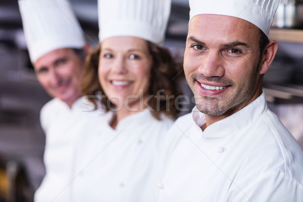 Group of happy chefs smiling at the camera  Stock photo © wavebreak_media