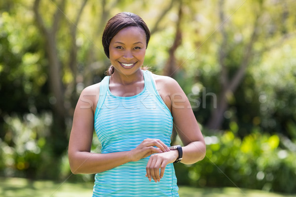 Happy woman posing and touching her watch Stock photo © wavebreak_media