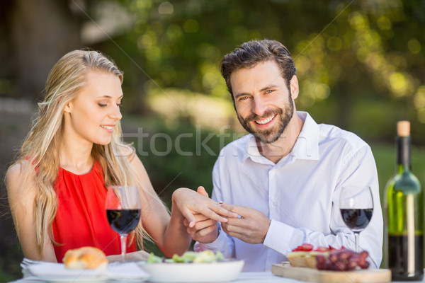 Man putting a ring on womans finger in the restaurant Stock photo © wavebreak_media