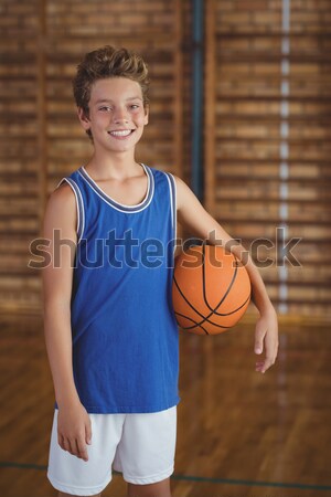 Portrait of smiling high school boy holding a basketball in the court Stock photo © wavebreak_media