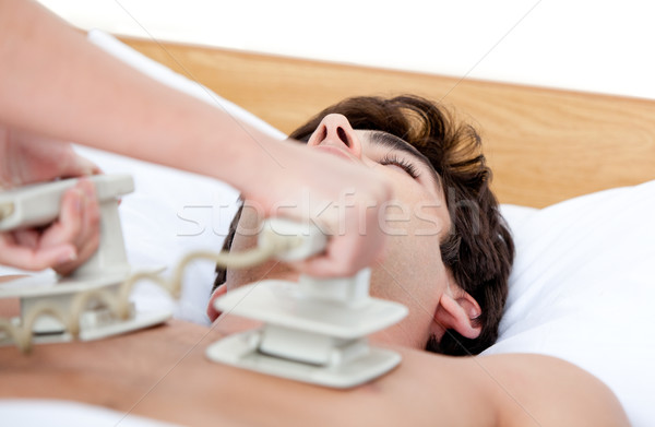 Male doctor using the defibrillator to reanimate an inconscious  Stock photo © wavebreak_media