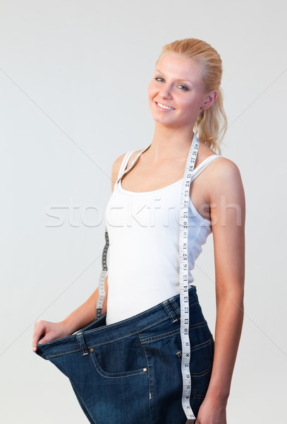 Beautiful woman wearing big jeans focus on woman  Stock photo © wavebreak_media