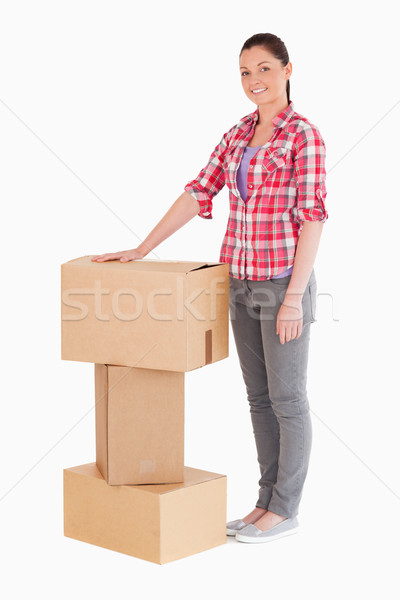 Beautiful woman posing with cardboard boxes while standing against a white background Stock photo © wavebreak_media