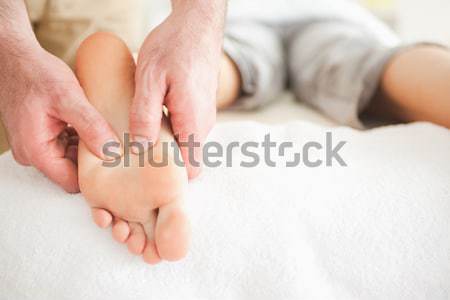 Male masseur massaging a woman's foot in a room Stock photo © wavebreak_media