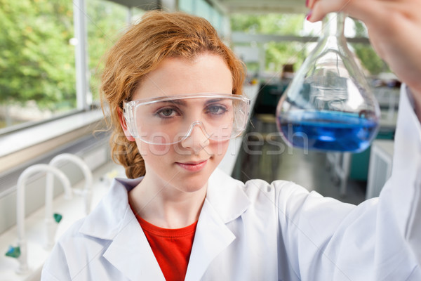 Science student holding a flask with protective glasses Stock photo © wavebreak_media