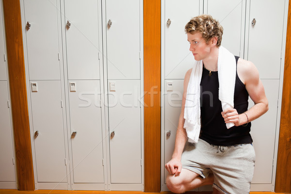 Handsome young sports student leaning on a locker with a towel Stock photo © wavebreak_media